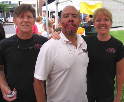 Annual Sidewalk Sale held under mostly clear skies The winner of the adult contest was Jose Ruiz of Monroe (center) posing with Noble Pies owners Tom Herman and Leslie Noble.