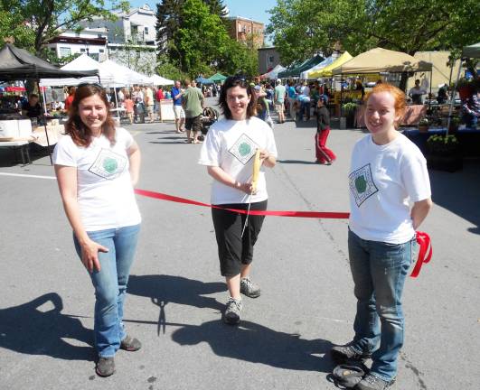 Warwick Farmers Market officially opened Sunday, May 13 Market Manager Kate Eicher (center), flanked by Assistant Market Managers Marisa 0íHara (left) and Samantha Alicia (right) prepares to cut the ribbon for the opening day of the Warwick Valley Farmersí Market.