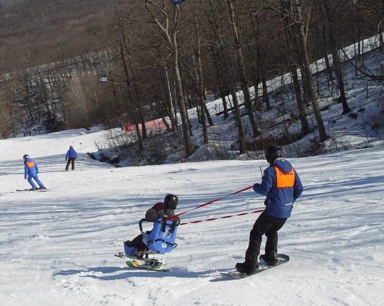Mountain Creek provides winter recreation for visitors with special needs Nick enjoys a run down the Horizon Slope guided by Tim Stone as Steve Baumann ensures a clear slope ahead. Photo: Dr. John T. Whiting
