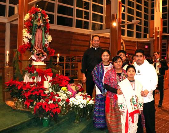 Bi-lingual Mass at St. Stephen's honors Our lady of Guadalupe Father Santiago posed with members of the Latino community in traditional costume..