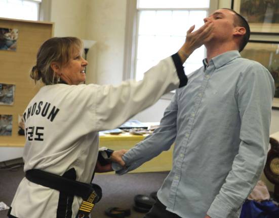 Rand Realty hosts self-defense class for real estate professionals Photo by Roger Gavan Master instructor Danielle Roche fends off a mock attack by volunteer Mike Vanmansart.