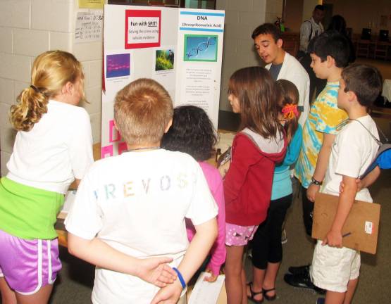 Warwick High School students help Sanfordville students appreciate chemistry Photo by Roger Gavan Alan Held, far right, explains how DNA evidence is used with saliva testing.