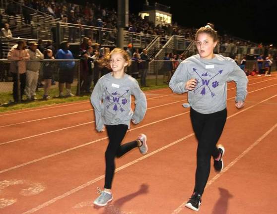 Go Mileage Club: Friday Night Lights Half Mile Run Kayla Scheurmann and Zofia Santagato approach the finish line of the Friday Night Lights Half Mile Run on Oct. 5.