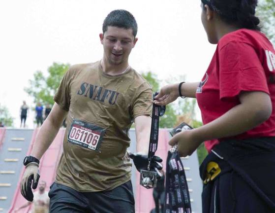 Thousands participate in Warrior Dash at Warwick Day Camp Photo by Robert G. Breese Ryan Balseiro of Warwick reaches the finish line after completing the Warrior Dash in Warwick on Saturday.