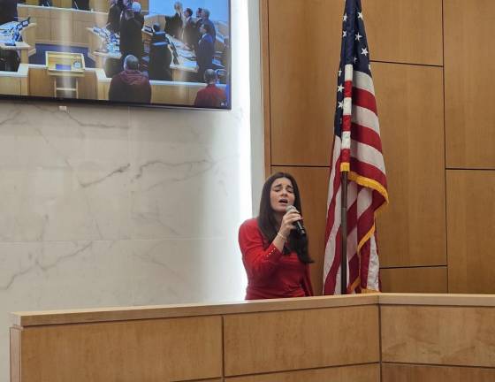 Julia Roome sings the National Anthem for Orange County lawmakers.