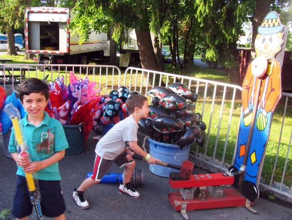 Sunny skies follow St. Stephens Parish Bazaar Photo by Roger Gaven Strongmen: John Rivera, 6,(left) and his cousin Michael Molinelli, 5, rang the bell for prizes.