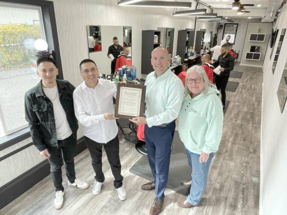 barber Erick , shop owner Iderson Suarez, Mayor Jesse Dwyer and Trustee Nancy Clifford