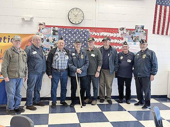 In attendance were (left to right) James Sosler, Robert Scott, Vincent Poloniak, William Pillmeier, Jr., Thomas Fuller, Sr., William Grohoski, John Cutrona, Jack Fein.The flag behind the veterans was made using the hand prints of every student at Golden Hill.