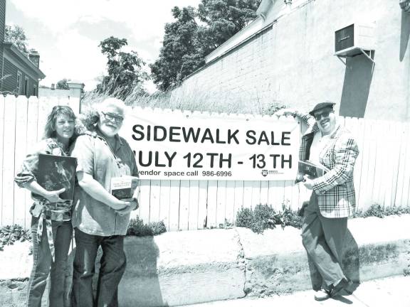 Sidewalk sale will feature 100s of vendors Photo by Roger Gavan From left, Literacy Orange Executive Director Christine Rolando and her Teddy Bear puppy Boo, Olde Warwick Book Shoppe owner Thomas Roberts and Sidewalk Sale Chair Tim Mullally.
