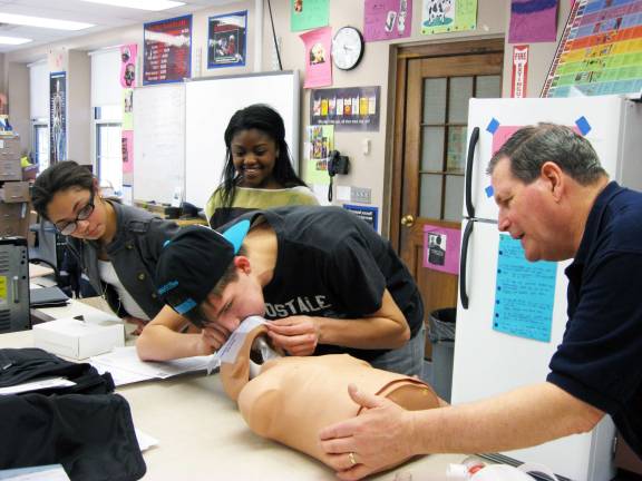 Baker sophomores trained to become life savers Tuxedo Volunteer Ambulance Corps EMTS provide the training Photo provided by Principal Denis M. Petrilak/George F. Baker High School George F. Baker High School Sophomores Leighann Navarruo, Monique Oparaji and Paul Jones learn rescue breathing and the use of an Automated External Defibrilator (AED) from Tuxedo EMT Bob Randhare.