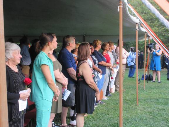 Family members stand during part of the ceremony