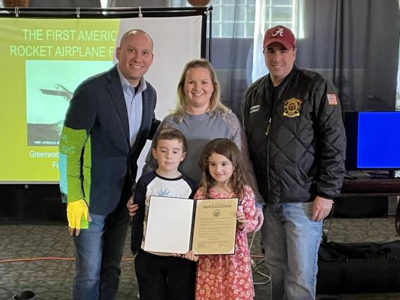 Rk2 Warwick Town Supervisor Jesse Dwyer stands with Jackie Lowenberg and her husband, Jon, and their two children, Jameson and Julia, who hold a proclamation declaring Feb. 23 as Gloria Rocket Mail Day. The Lowenbergs are descendants of Gloria Quakenbush, the namesake of the rocket airplane that carried mail across Greenwood Lake from New York to New Jersey on Feb. 23, 1936. (Photos by Peter Lyons Hall)