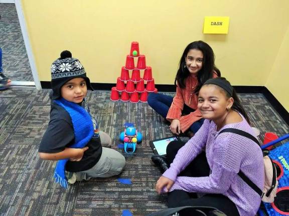 Kids become engineers at Robotics4U Tanya Sinha, center, with friends. The robot has just released the green ball hitting the pyramid (Photo by Ginny Privitar)