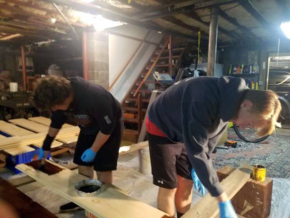 The timing was perfect Max Hartman and Mark Pennings stain floor boards.