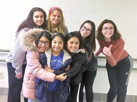 The tutors: Standing behind some of the students they tutor at the Warwick Area Migrant Committee are, from left to right, Warwick Valley High School students Elizabeth Centorrino, Billie Finn, Cameron Quinn and Charlotte O'Connor.