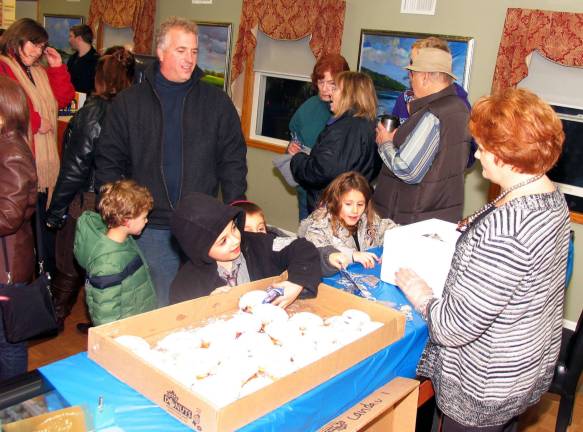The Warwick Menorah shines anew The crowd then headed down Main Street to Forever Jewelers where they were served latkes prepared by Doris Schwartzberg (right) and jelly donuts brought by Rabbi Meir Borenstein from the Chabad Center of Orange County.