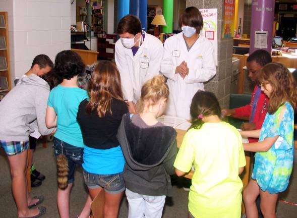 Warwick High School students help Sanfordville students appreciate chemistry Photo by Roger Gavan Pavel Gorelov and Michael Dimartino performed a maggot test on a dead rat found at the crime scene to determine the time of the kidnapping.