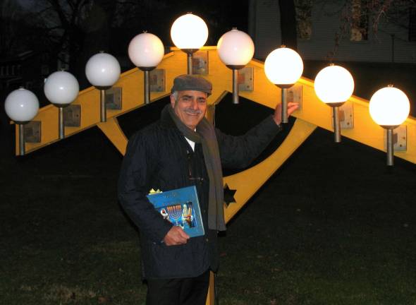 Warwick residents celebrate Hanukkah at 20th anniversary of Warwick Menorah lighting Moshe Schwartzberg lights the the third lamp. Additional photos appear online at warwickadvertiser.com.