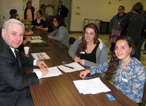 The shadow learns Handwriting and document expert Robert Baier explains the details of his trade to high school juniors Danielle Keesler (left) and Cassie Pacelli.