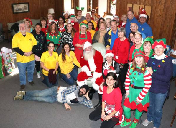 Warwick community unites to help needy children and their families Photo by Roger Gavan Members of the Warwick Valley Rotarians, the Warwick Lions Club and other volunteer “Elves,” pose with Santa.