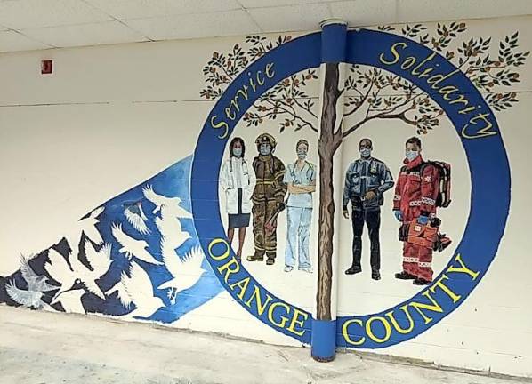 Goshen. In service and solidarity Members of the Bruderhof Community in Chester painted this mural at the COVID-19 vaccination POD (Point of Dispensing) in the Orange County Emergency Services Center in Goshen. The photo was provided to the Warwick Fire Department by Brendan Casey, the county’s Commissioner of Emergency Services. The photo, in turn, was provided to the newspaper by Michael Contaxis, the Warwick Fire Department’s 1st assistant chief. Contaxis also noted that the Bruderhof Community “always step up to help.”