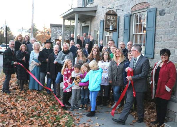 Baird's Tavern celebrates official grand opening Photo by Roger GvanOn Thursday, Nov. 16, Town of Warwick Supervisor Michael Sweeton (far right), Mayor Michael Newhard (far left) and members of the Warwick Valley Chamber of Commerce joined Adam Powers (rear right), his staff, officials and members of the Warwick Historical Society and their families and friends to celebrate the official grand opening of Baird's Tavern with a ribbon-cutting.