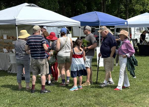 Farmers Market vendors welcome parade crowd A line of customers outside Flower & Dough on July 5, 2025.