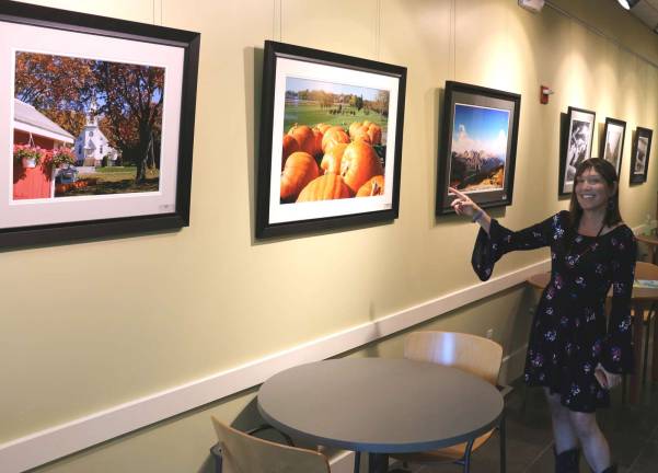 Albert Wisner Library features photography exhibit this month Photo by Roger Gavan Photographer Susie Schmieder points to several photographs of local scenes in her "Everywhere" exhibit now on display through July at the Albert Wisner Public Library.