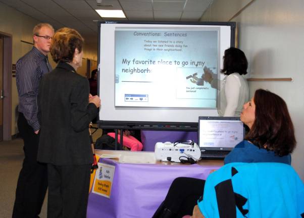 Techn Expo held at Warwick Valley From left, student teacher Scott Hellstein, Dr. Marijane Reinhard, assistant superintendent for curriculum, Sanfordville Elementary second grade teacher Katherine Valentine demonstrating the use of the Smart Board in her ELA and Math lessons and seated, Sanforville second grade teacher Nancy Donohue.