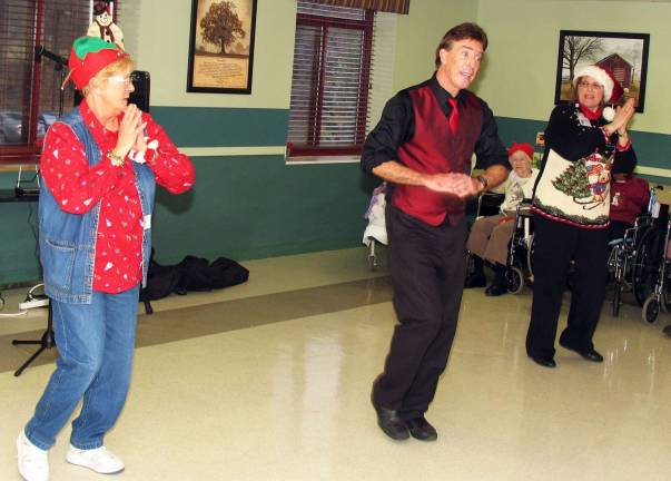 Schervier Pavilion hosts Christmas party ìClap your hands!î From left, volunteer Pat De Negri, entertainer Kevin Curry and recreation aide Roselle Egan perform a dance routine for the residents.