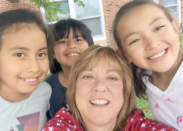 Katherine Brieger is pictured here with children at the Alamo in Pine Island, an HRHCare Health Center providing services to migrant children. Provided photo.