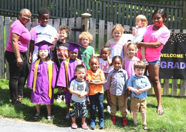 Warwick Love Grows Child Care celebrated First Steps Achievement Photo by Roger Gavan Director Cecelia Cenot (left) and teacher Paige Harris pose with graduates and other children at Love Grows Child Care in the Village of Warwick.