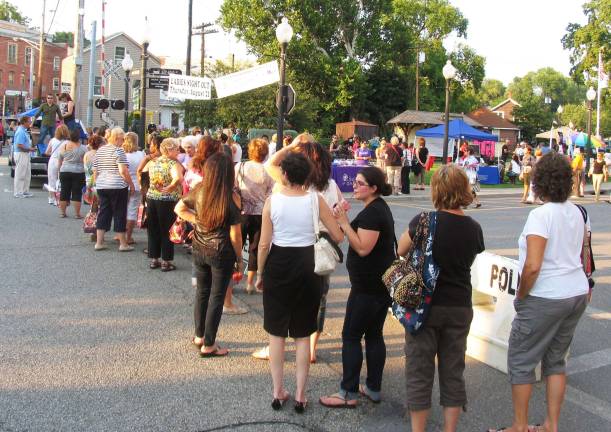 Ladies Night Out draws large crowds to downtown Warwick Ladies lined up for a red rose and other prizes at a bean bag toss sponsored by Leo Kaytes Ford.