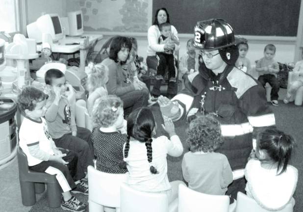 Kids, firefighters and safety A firefighter got dressed in his bunker gear to show the young children that he was not a scary person with his mask and other equipment.