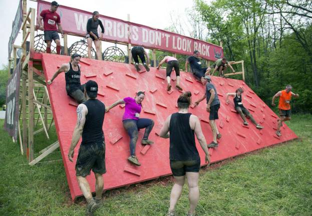 Thousands participate in Warrior Dash at Warwick Day Camp Photo byRobert G. Breese Participants in the Warrior Dash in Warwick make there way down a wall during the 5K 12 obstacle course on Saturday.