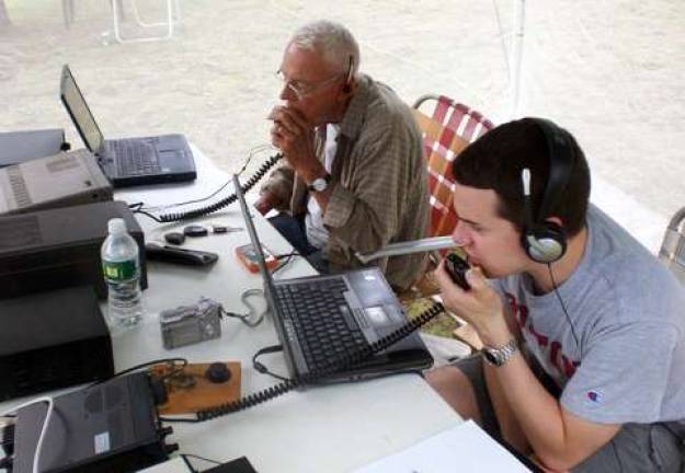 Who ya gonna call when disaster strikes? Grandfather and grandson on the air at Field Day 2011: Andrew J. Maroney Jr., W2SON, and Andrew J. Maroney IV, W2AJM, operate two stations in the tent at Field Day.