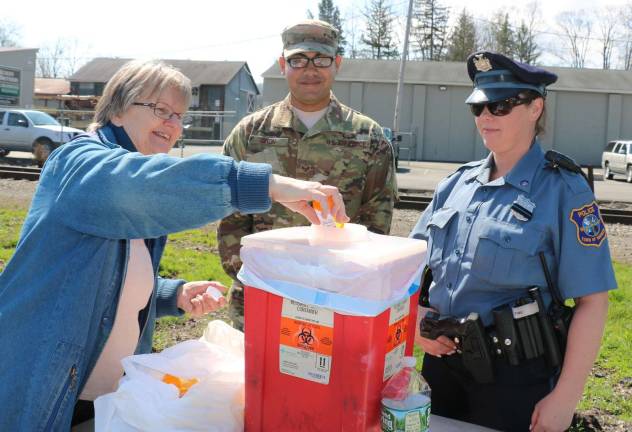 Sgt. Luis Giron, a member of the USAF National Guard assigned to the Counter Drug Task Force, and Warwick Police Officer Amie McGrady look on as Veronika Doherty gets rid of pain-killer drugs no longer needed by her husband, Dennis, who succeeded with a different treatment. &quot;This,&quot; she said, &quot;is the best idea ever.&quot;