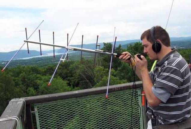 Who ya gonna call when disaster strikes? Andrew Mennerich, K2FR makes contact with a ham satellite during Field Day, on the tower at Cronomer Hill Park.