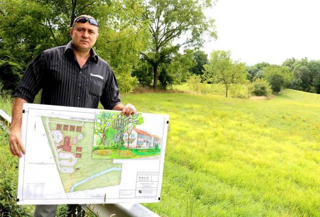 Developer Stephen Kitar poses with his plan and an artist rendition of the proposed inn outside the almost 10 acre property along West Street identified by the prominent formation known as “Pulpit Rock.” File photo by Roger Gavan.