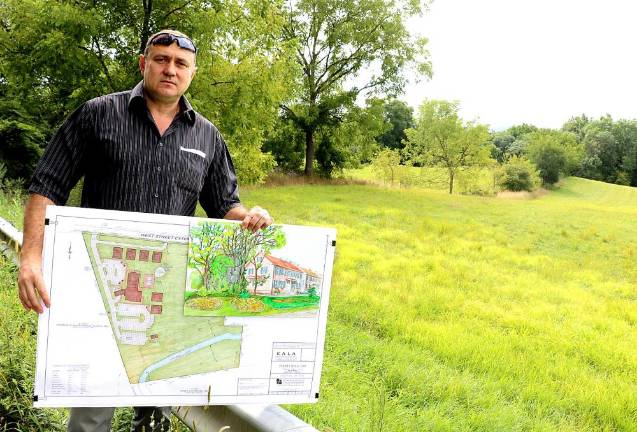 Developer Stephen Kitar poses with his plan and an artist rendition of the proposed inn outside the almost 10 acre property along West Street identified by the prominent formation known as “Pulpit Rock.” File photo by Roger Gavan.