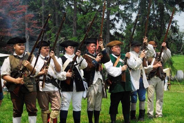 The way we were Photo by Mark Coiro Colonial re-enactors representing the rebel side take aim and fire from their muskets.