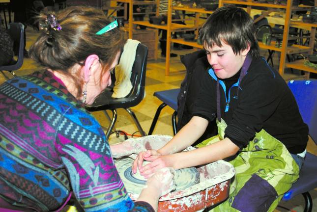 At last year&#x2019;s Empty Bowls event, local potter Roberta Green of RG Clay Creations teaches a child to create his own mini-pot as part of the kids&#x2019; activity area.