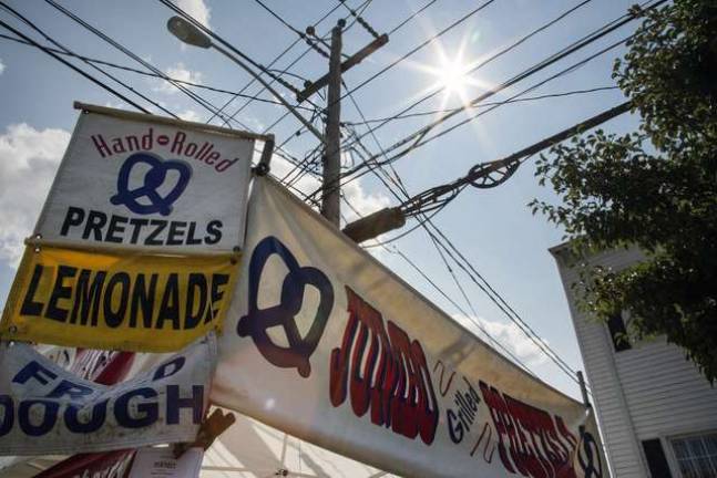 Celebrating community in Florida, NY Banners fly above a pretzel and lemonade tent on a clear day during the Florida Funfest along Main Street last Sunday, Aug. 10.