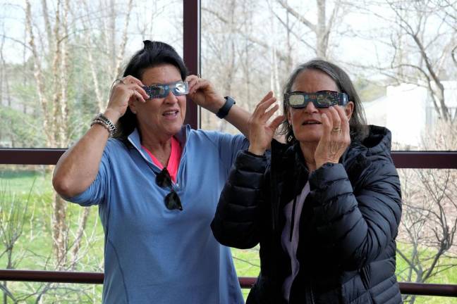 The eclipse was watched by a small crowd of adults and children on this partly cloudy day.