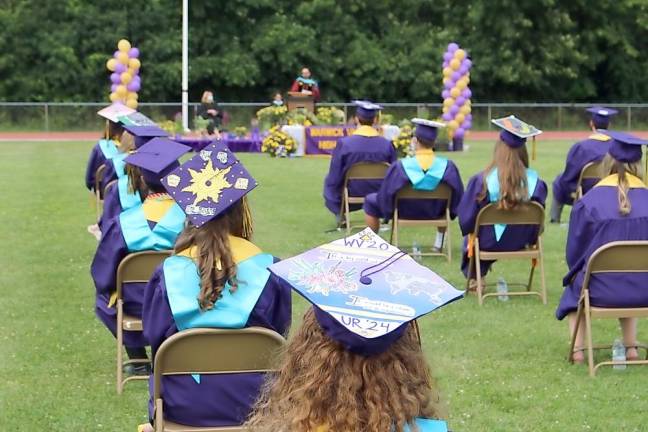 Students listen to Superintendent of Schools Dr. David Leach during a ceremony.
