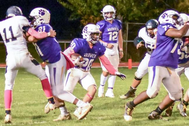 Warwick’s Dan Thorson (#20) runs behind junior tackle Christian Felix (#73) and sophomore Tight End Latrell Willis (81) in Wildcat win over Pine Bush last Friday, Oct. 29, at C. A. Morgan Field. Photo by Al Konikowski.