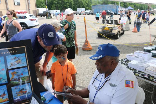 Airshow draws record crowd this weekend in West Milford Photos by Don Webb Tuskegee Airman Eugene Richardson Jr. Richardson signs autographs at the Greenwood Lake Airport Air Show.