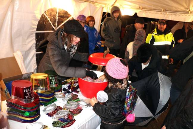 Ring in the new The tent on Railroad Green offers shelter from the rain as Mary Collura and other volunteers hand out treats.