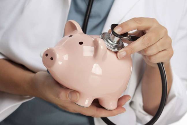 Healthy, wealthy, and wise: These financial New Year's resolutions will carry you through 2019 and beyond Female Doctor Holding Stethoscope to Pink Piggy Bank Abstract.