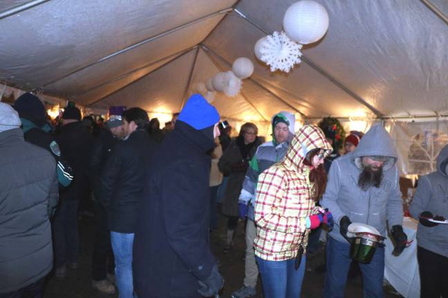 A year to remember Another large crowd celebrates New Year's Eve and Apple Eve on Railroad Avenue Visitors braved the cold inside the tent with hot drinks and baked goods.